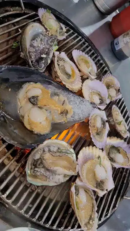 불판 위에서 맛있게 구워지는 조개들