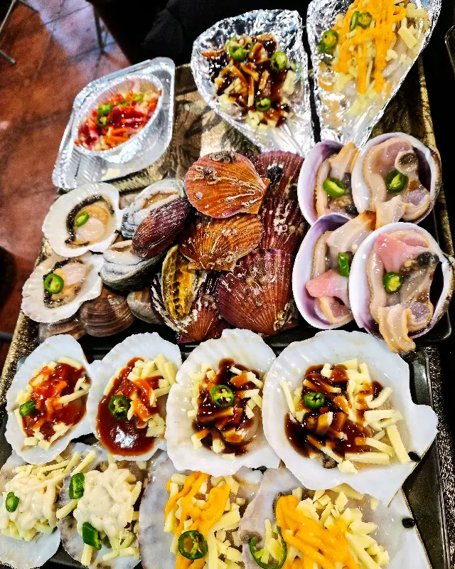 다양한 조개와 곁들임 메뉴가 푸짐하게 차려진 모습