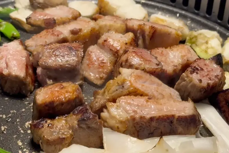 불판 위에서 윤기 자르르 흐르는 목살이 구워지고 있는 모습