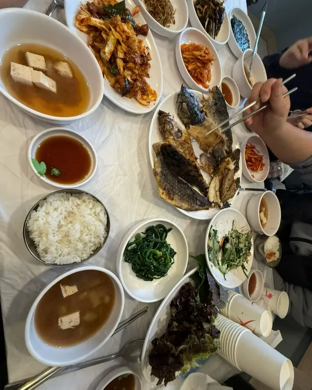 가자미회무침, 생선구이, 밑반찬, 된장찌개, 쌈채소 등이 한 상 가득 차려진 모습