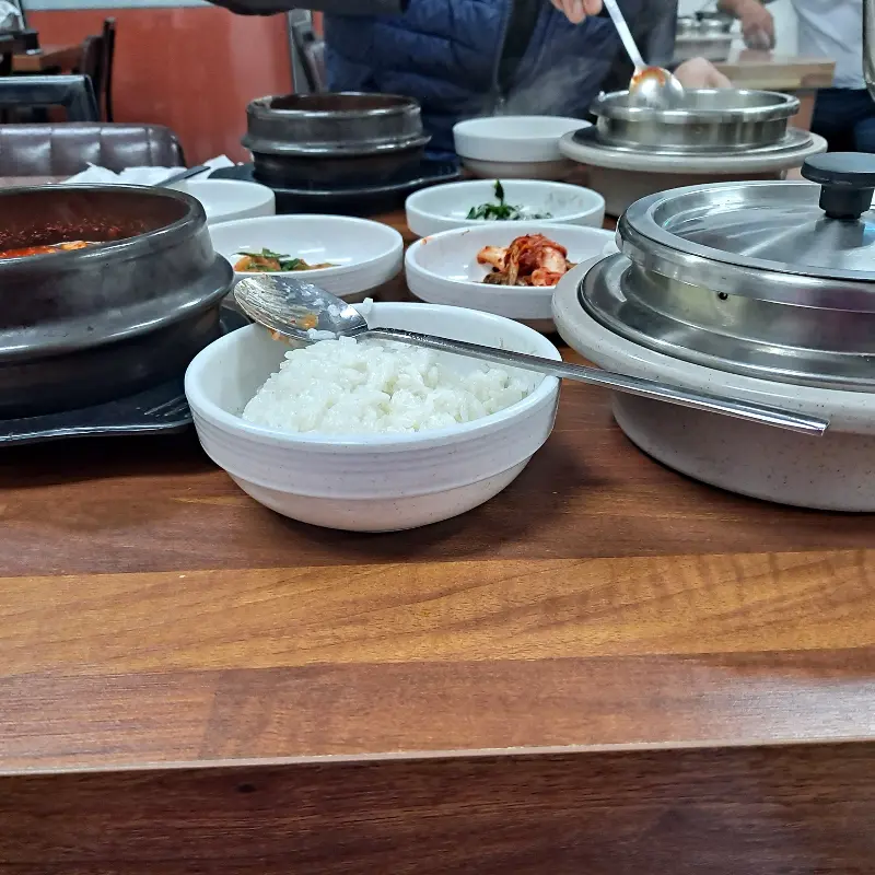 테이블에 놓여진 솥밥과 순두부찌개