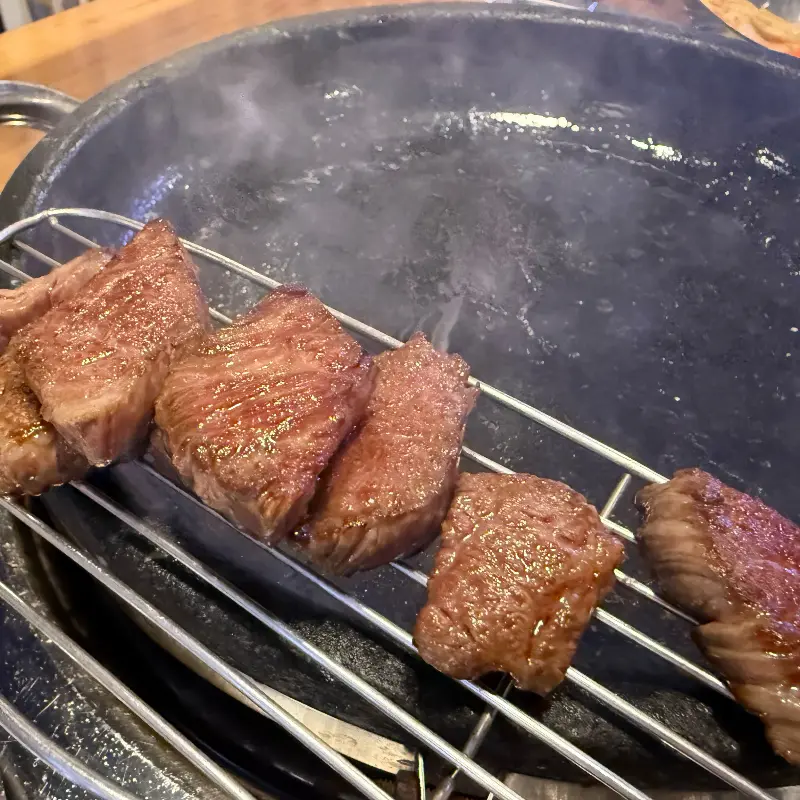 불판 위에서 노릇하게 구워진 숙성 목살