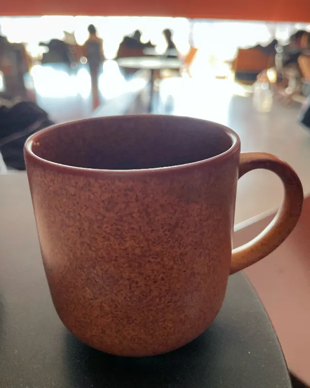 따뜻한 색감의 머그잔에 담긴 커피