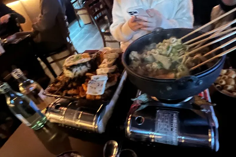 테이블 위에 놓인 전골과 철판 요리 사진