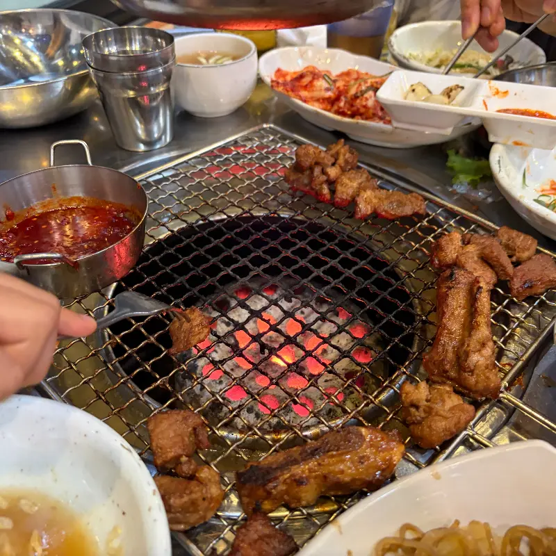 불판 위의 돼지갈비와 푸짐한 밑반찬