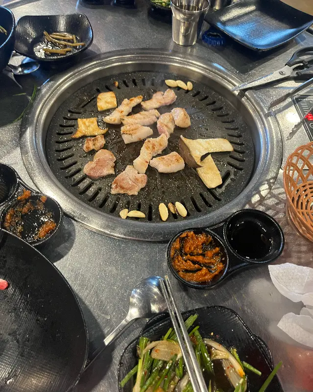 불판 위의 고기와 밑반찬