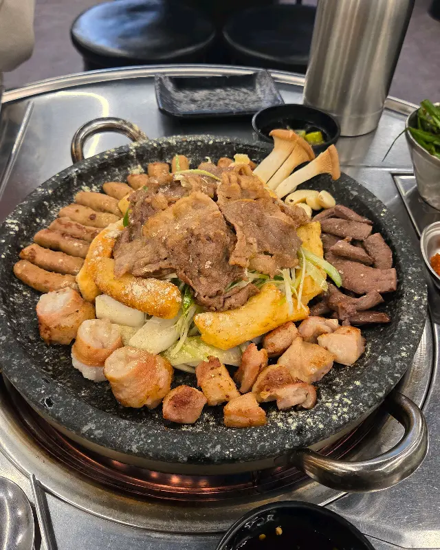 모듬 곱창이 거의 다 먹어갈 때쯤, 불판 위에 우삼겹과 곱창이 함께 구워져 있다. 우삼겹은 얇게 썰어져 있고, 곱창은 통통하게 썰어져 있다.