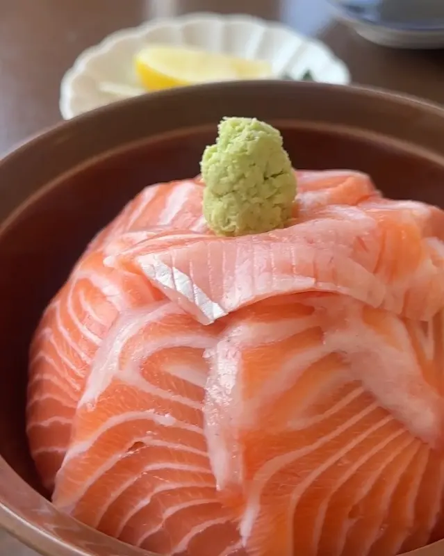 신선한 연어가 밥 위에 가득 올려진 사케동의 아름다운 모습