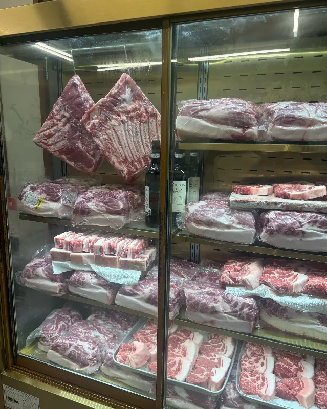다양한 부위의 돼지고기가 냉장고에 진열되어 있는 모습