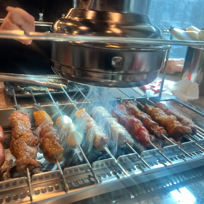 숯불 위에서 익어가는 다양한 꼬치들