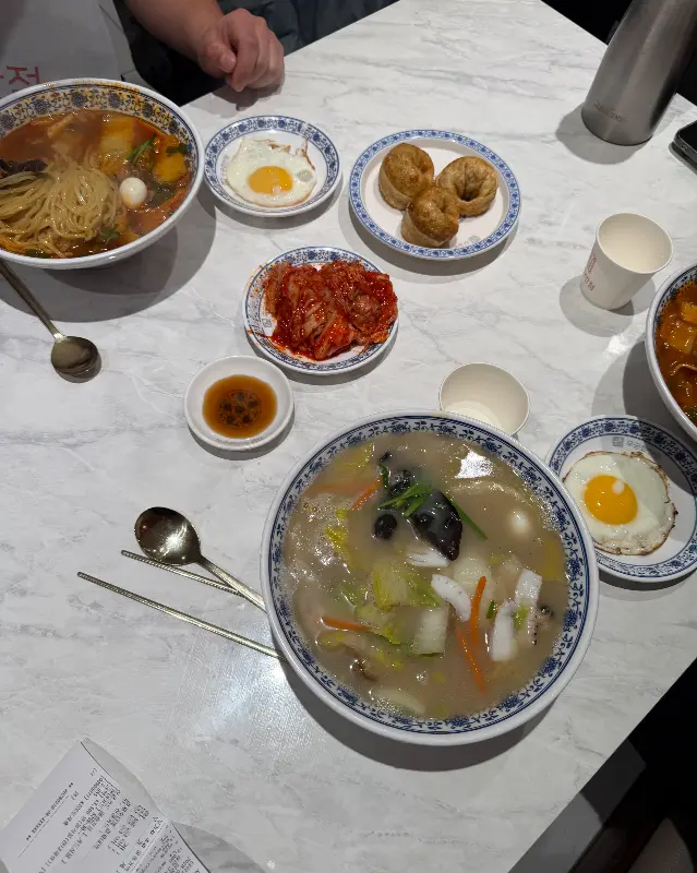테이블 위에 놓인 짬뽕, 계란후라이, 김치