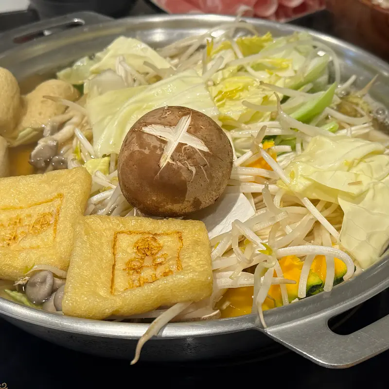 샤브샤브 육수에 야채와 버섯, 유부를 넣어 끓이는 모습