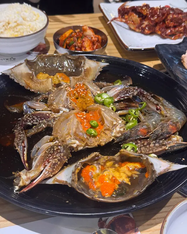 밥, 김치, 냉수육, 간장게장이 놓여진 테이블 전경