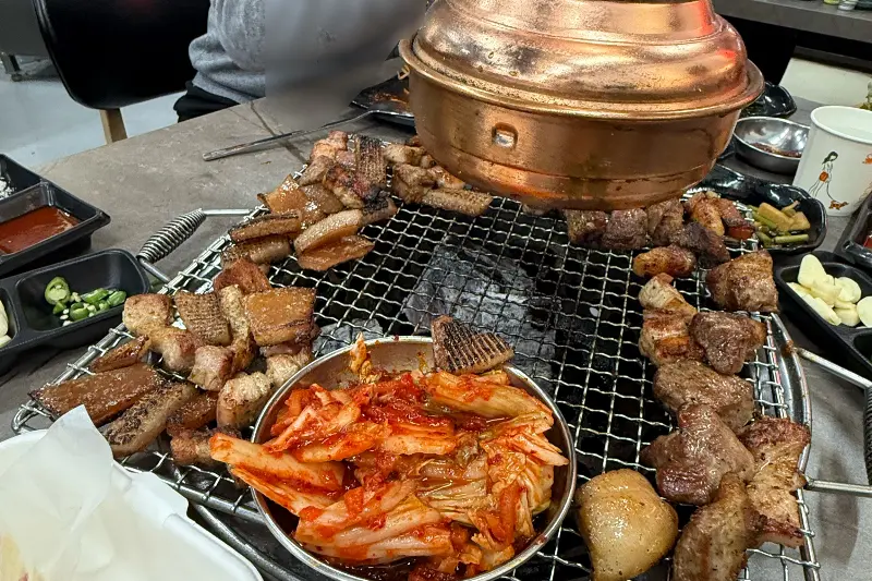 잘 구워진 삼겹살과 김치가 놓여진 불판