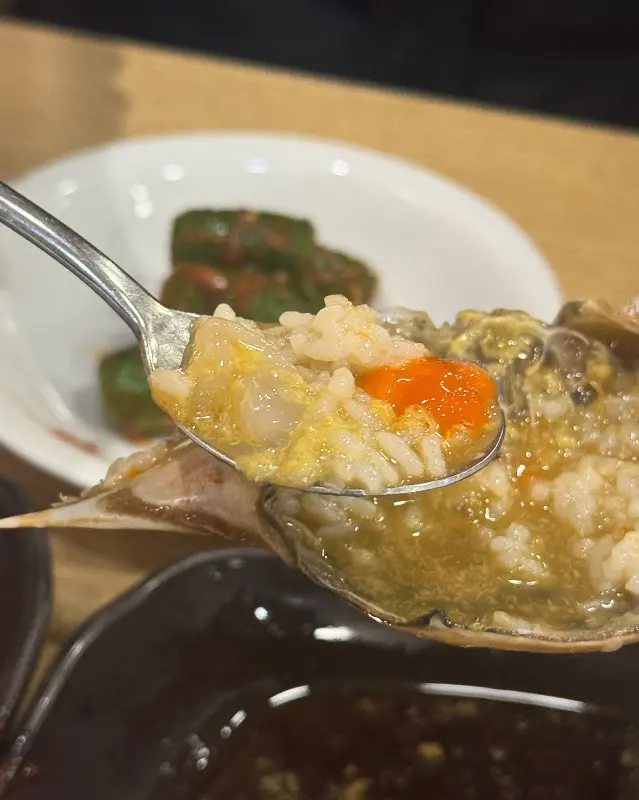 게 뚜껑에 밥을 비벼 먹는 모습