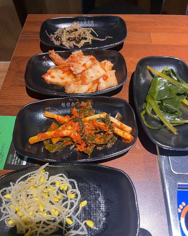 쌈 채소에 고기, 쌈장, 마늘을 올려 한 쌈