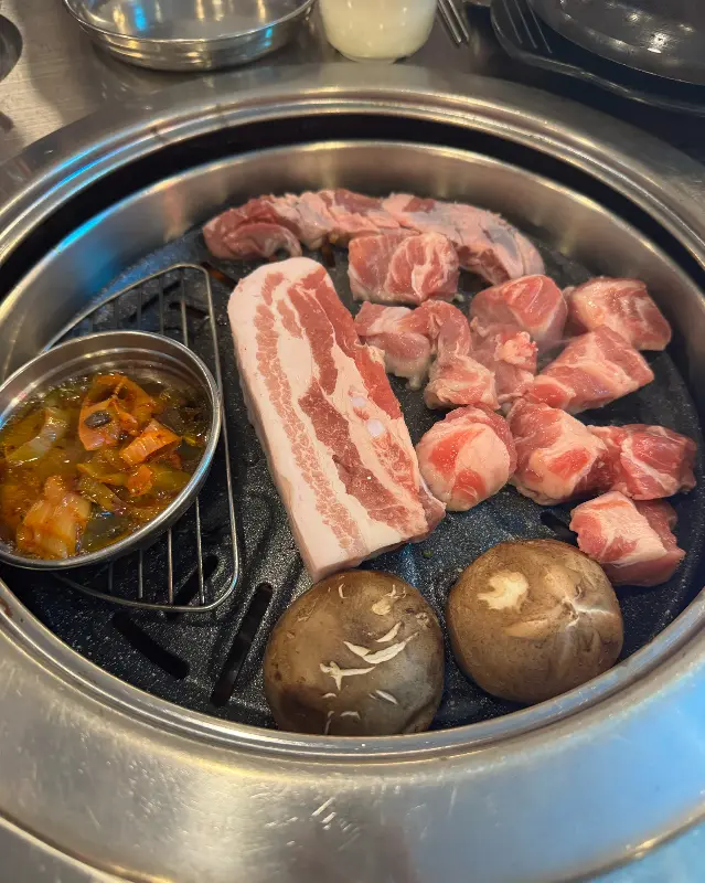 숯불 위에서 익어가는 삼겹살과 버섯