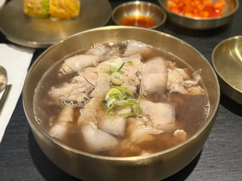 곰탕과 배추만두, 깍두기가 함께 차려진 푸짐한 한 상