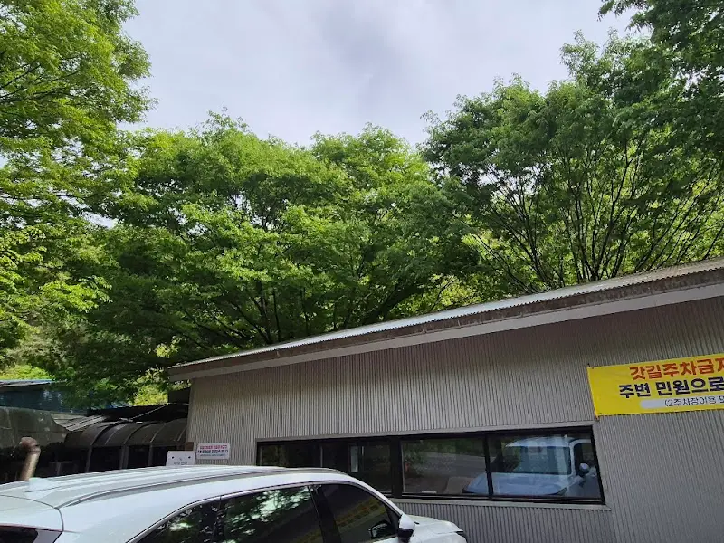 푸르른 나무들이 감싸고 있는 촌두부집 건물