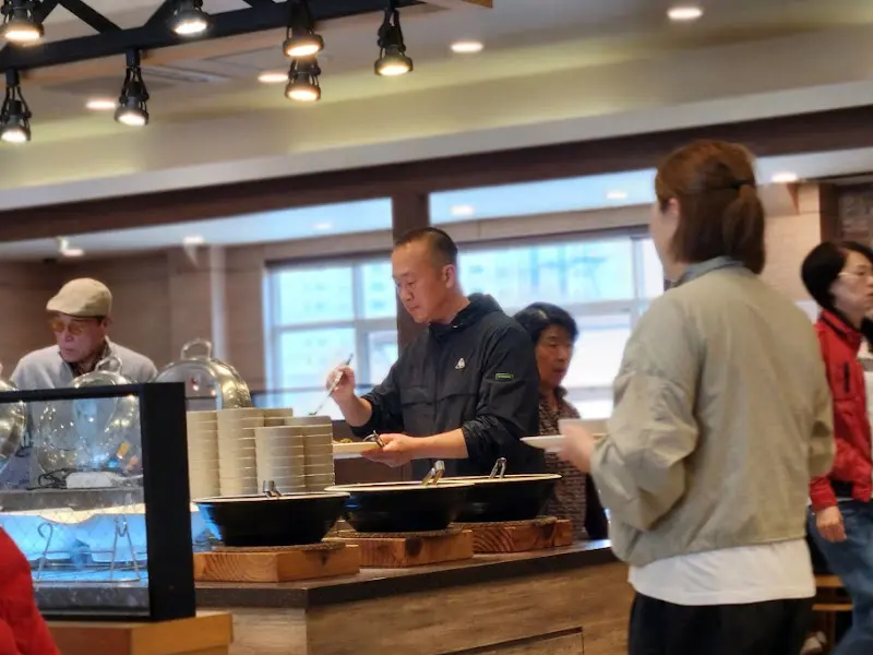 뷔페 코너에서 음식을 담는 사람들