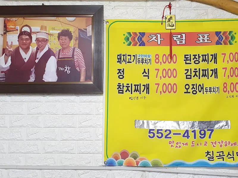 벽에 걸린 메뉴 가격표와 유재석, 조세호 사진