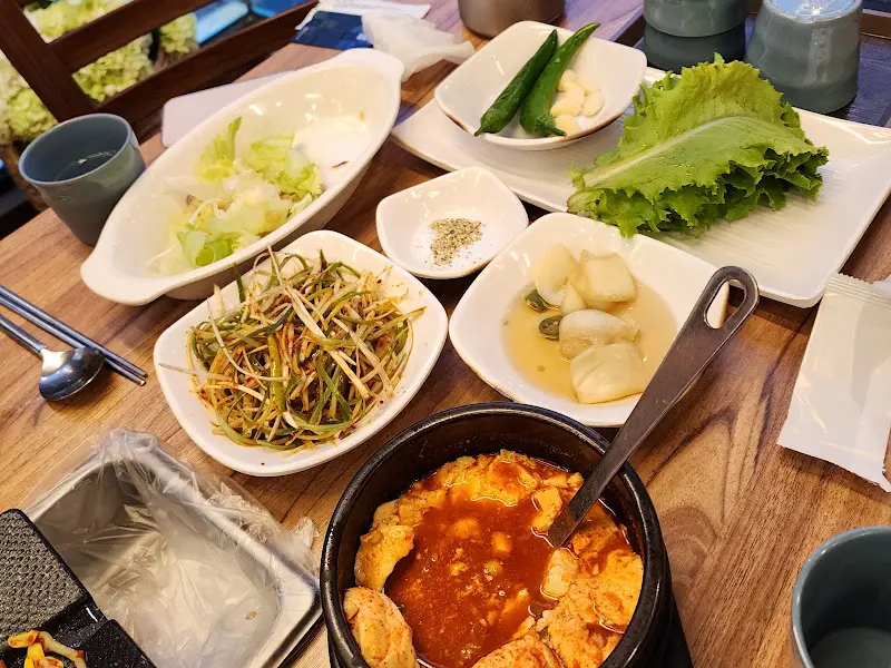 테이블 위에 차려진 다양한 쌈 채소와 밑반찬들