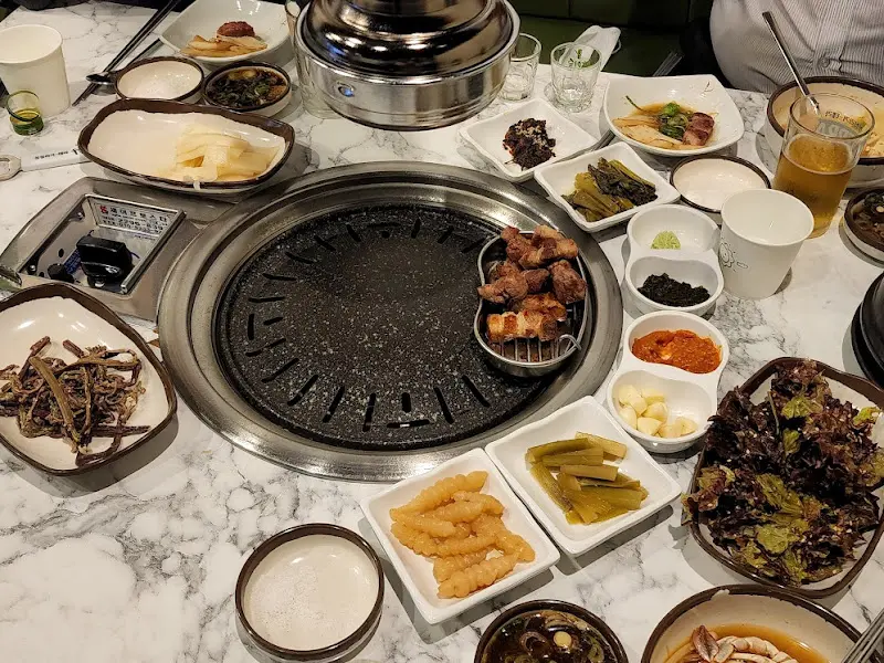 다채로운 밑반찬과 고기가 세팅된 테이블 전경