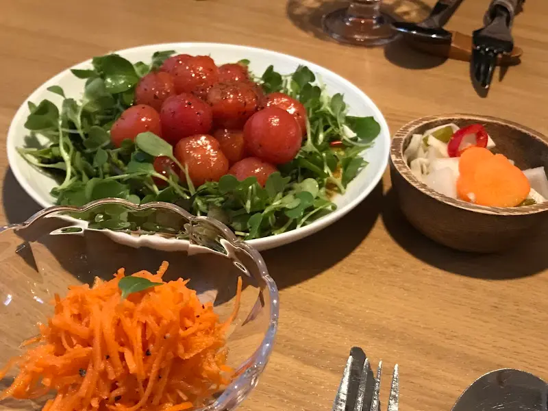 토마토 샐러드와 피클, 당근 절임이 놓여있는 테이블