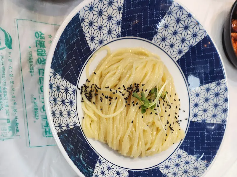 검은깨가 뿌려진 크림색 콩국수