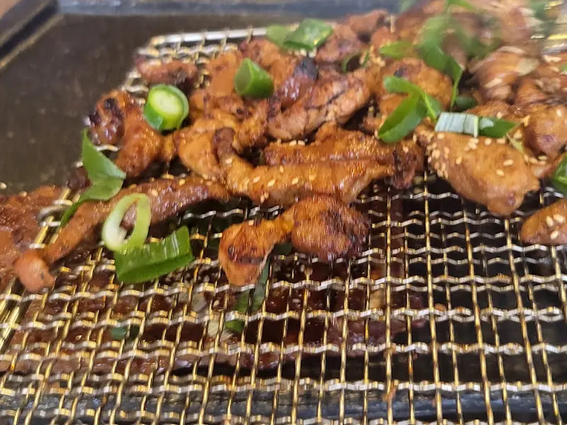 숯불 위에서 노릇하게 구워진 흑돼지