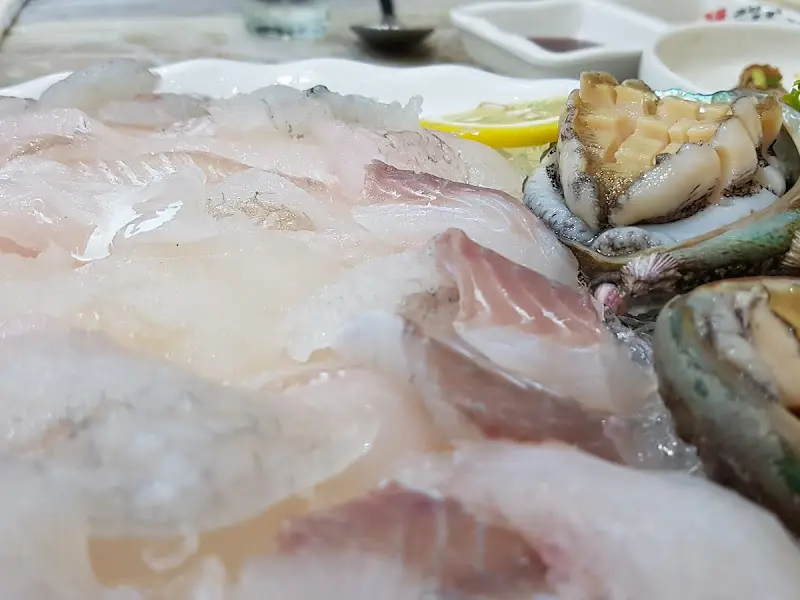 신선한 회와 해산물이 얼음 위에 보기 좋게 담겨 있는 모습