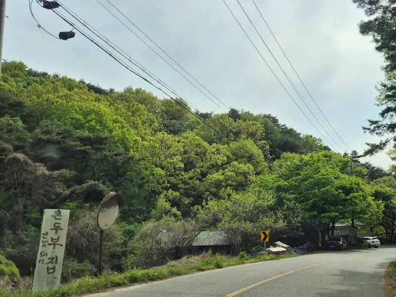 푸르른 나무들로 둘러싸인 촌두부집으로 향하는 꼬불꼬불한 길