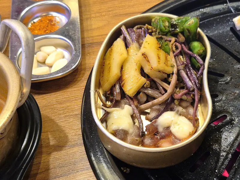 불판 위에 구워진 파인애플과 고사리의 모습