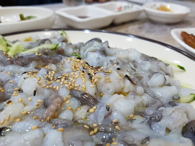 참기름과 깨소금이 뿌려진 산낙지가 접시에 담겨 있는 모습