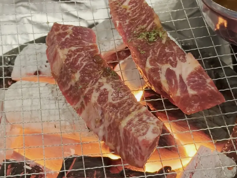 숯불 위에서 익어가는 두툼한 소갈비