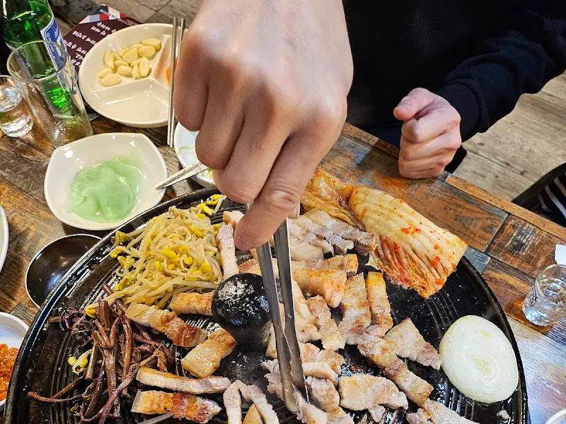 노릇노릇 구워진 삼겹살과 김치, 콩나물