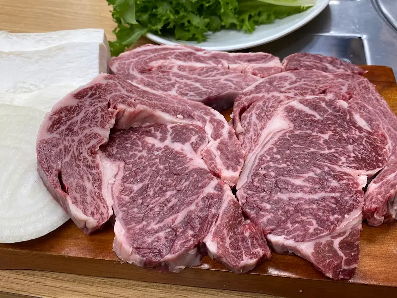 나무 도마 위에 놓인 큼지막한 한우. 마블링이 예술이다.