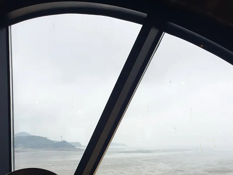 둥근 창문 너머로 보이는 흐린 바다