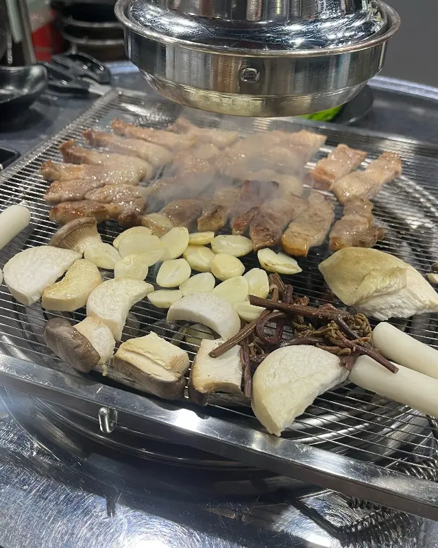 고기와 버섯, 떡을 함께 구워먹는 모습