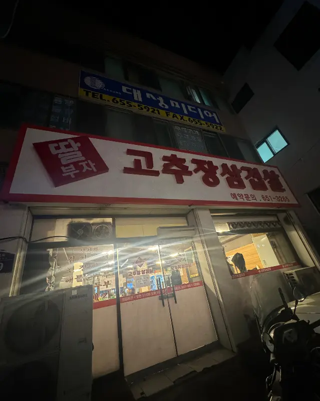 밤에 빛나는 딸부자 고추장삼겹살 간판의 모습