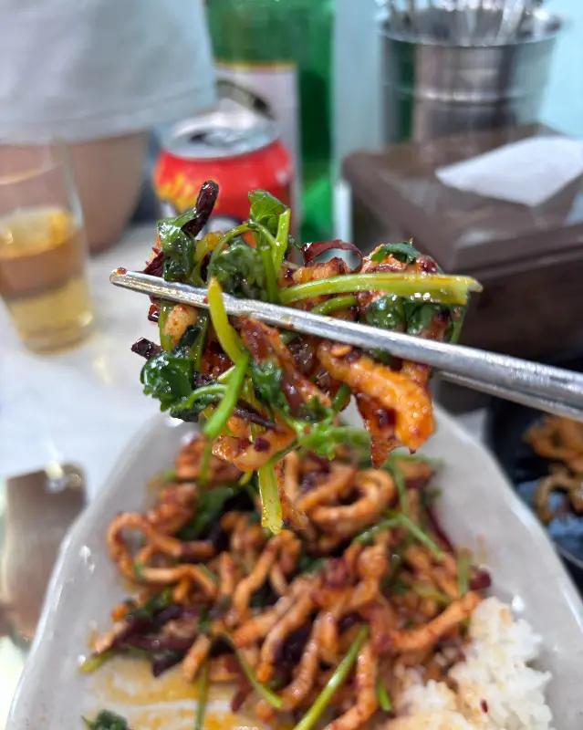 젓가락으로 집은 고추육슬덮밥