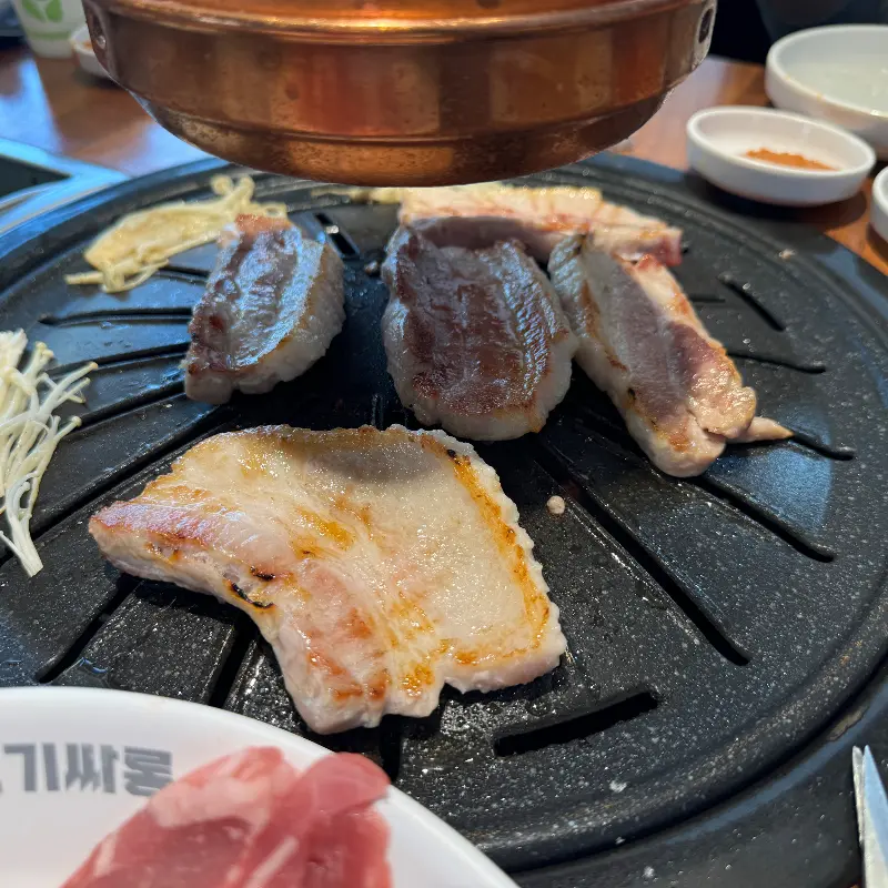 불판 위에서 노릇하게 구워지는 삼겹살