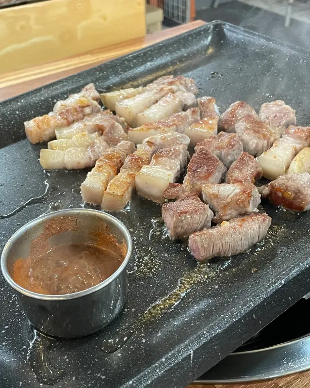 멜젓에 찍어 먹음직스럽게 익은 흑돼지 오겹살