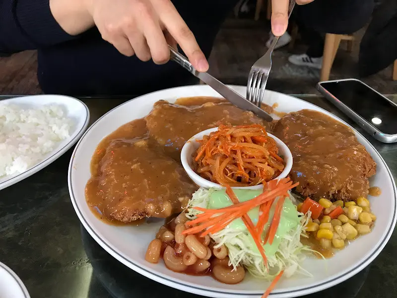 칼과 포크로 돈까스를 써는 모습