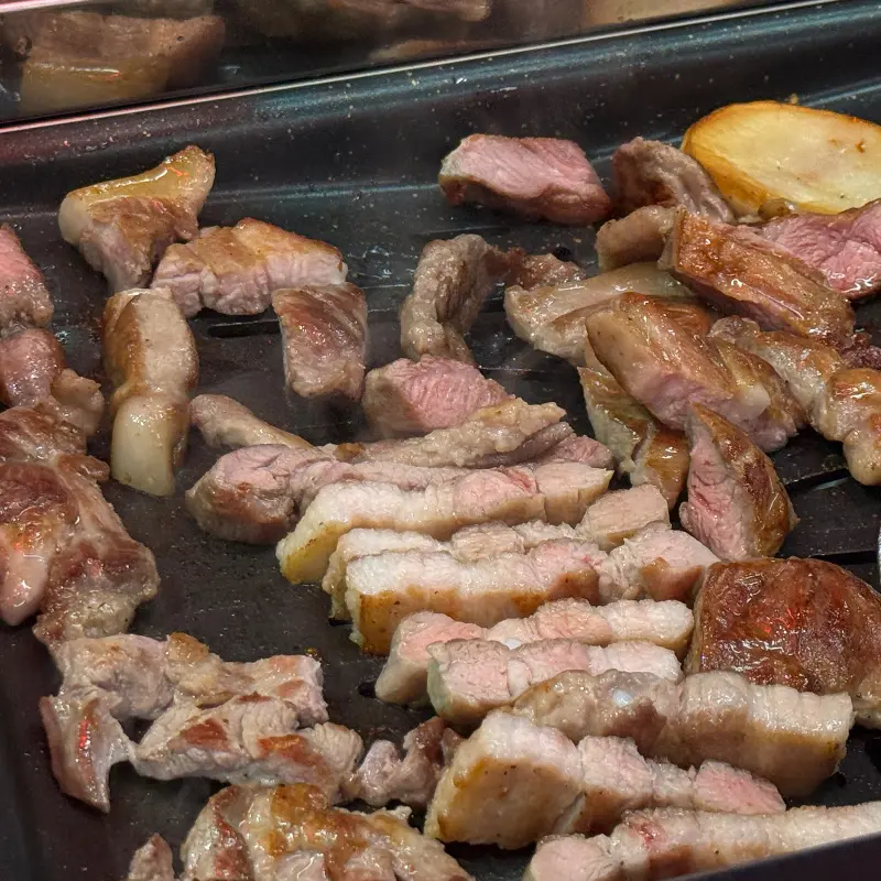 잘 구워진 고기가 불판 위에 놓여 있는 모습
