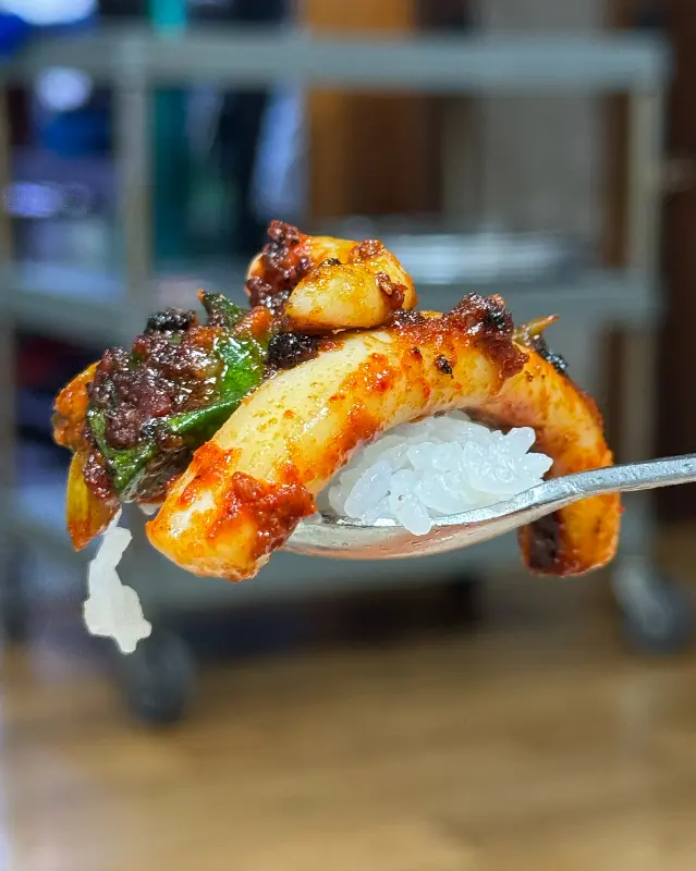 오징어 불고기를 밥 위에 올려 한 입 가득