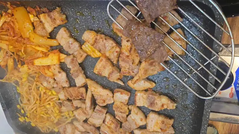 불판에 구워진 삼겹살과 김치