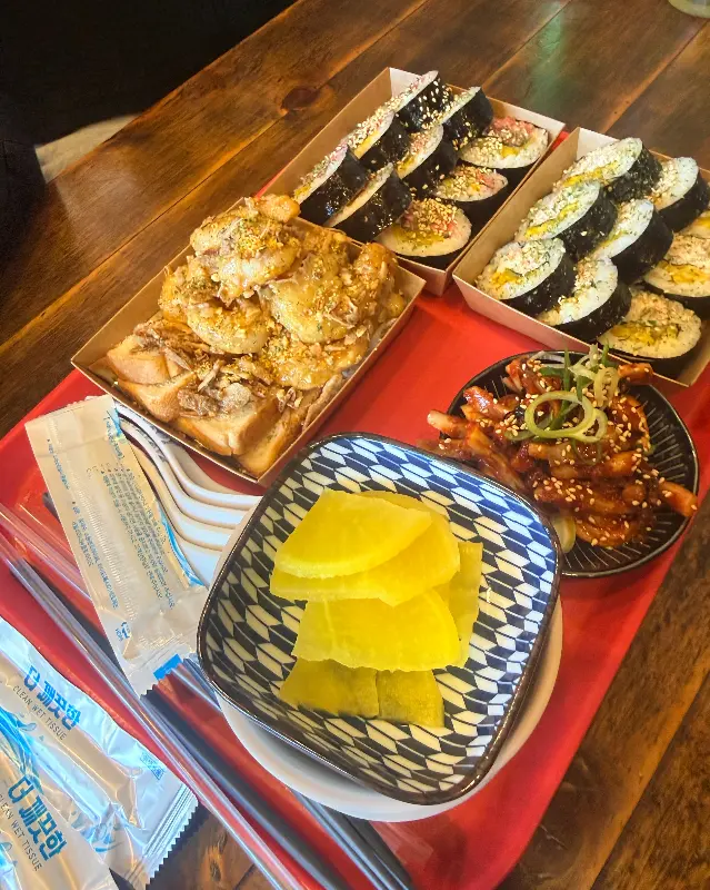 테이블 위에 놓인 딱새우라면, 김밥, 갈릭새우