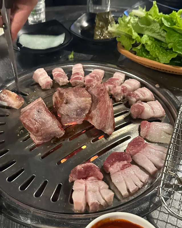 연탄불 위에서 구워지는 흑돼지의 모습