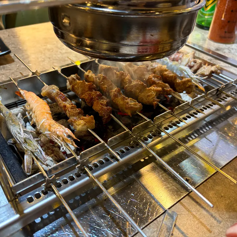 다 익은 양꼬치와 새우를 함께 즐기는 모습